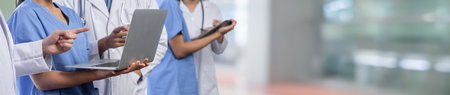 Medical staff team with doctor nurse and specialist working together with laptop and tablet on blur...