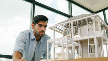 Professional architect engineer comparing between blueprint house model. Businessman decide to invested money in real estate project. Project manager checks house by comparing with plan. Traceryの写真素材