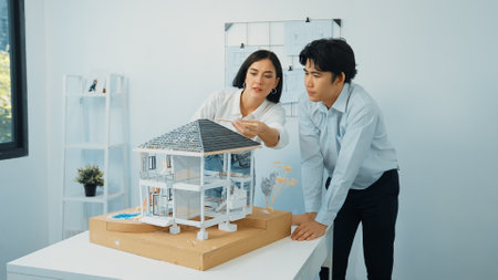 Closeup of young professional skilled architect engineer team focusing on checking the house model structure at modern office. Creative professional design and teamwork concept. Immaculate.の写真素材