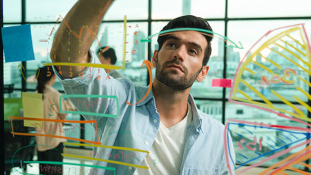Professional businessman uses sticky notes at glass wall with graph to brainstorming idea while...