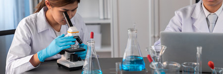 Group of dedicated scientist conduct chemical experiment using microscope in medical laboratory to develop new vaccine drug or antibiotic. Biotechnology lab and medicine research concept. Neotericの写真素材