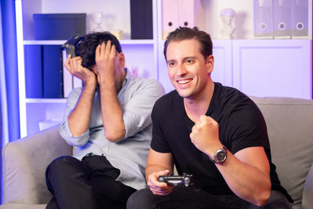 Winner and loser players of buddy friend gamers playing video game on TV using joysticks in studio...