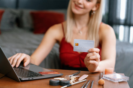 Young woman using laptop with credit card for internet banking, online shopping E commerce by online payment gateway at home office. Modern and convenience online purchasing with debit card. Blitheの写真素材