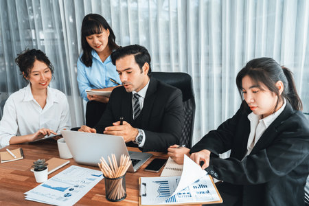 Diverse group of business analyst team analyzing financial data report paper on office table. Chart and graph dashboard by business intelligence analysis for strategic marketing planning Meticulousの写真素材