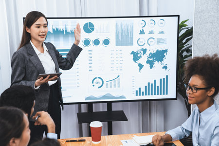 Young asian businesswoman presenting data analysis dashboard on TV screen in modern meeting....