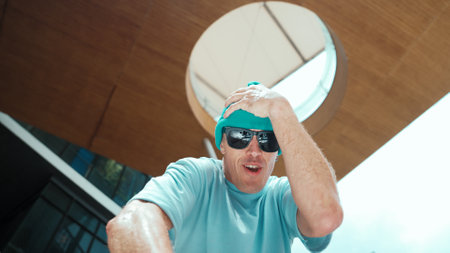 Low angle portrait of caucasian handsome hipster looking at camera while pose cool posing. Stylish lively dancer smile while practicing freestyle dance. Outdoor sport 2024. Endeavor.の写真素材