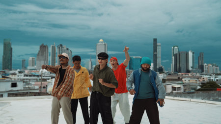 Closeup of street dancer wear colorful outfit while dance together. Group of attractive hipster dance and move to hip-hop music at skyscraper and city view. Break dance. Outdoor sport 2024. Endeavor.の写真素材