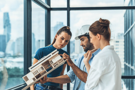 Smart engineer holds house model and explain about house construction to skilled manager. Group of...