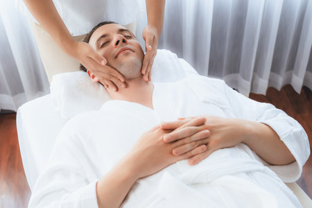 Caucasian man enjoying relaxing anti-stress head massage and pampering facial beauty skin recreation leisure in dayspa modern light ambient at luxury resort or hotel spa salon. Quiescentの写真素材