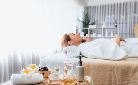 Aromatherapy massage on daylight ambiance or spa salon composition setup with focus decor and spa accessories on blur woman enjoying blissful aroma spa massage in resort or hotel background. Quiescentの写真素材