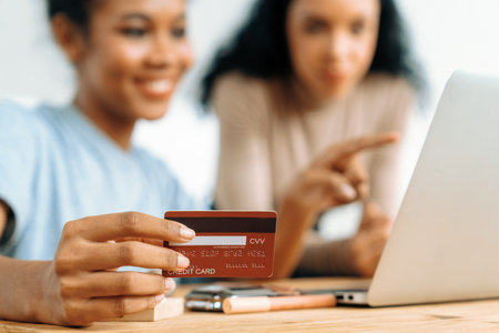 Young happy woman buy product by online shopping at home while ordering items from the internet with credit card online payment system protected by crucial cyber security from online store platformの写真素材