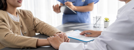 Doctor show medical diagnosis report and providing compassionate healthcare consultation while holding young patient hand for being supportive and professional in doctor clinic office. Neotericの写真素材