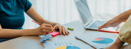 Startup company employee working together, analyzing BI dashboard paper on financial data report and...