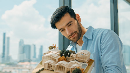 Businessman in casual outfit holding house model while checking house construction. Architect...
