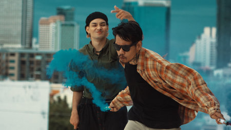 Group of multicultural hipster playing color flare at rooftop. Attractive street dancer holding...
