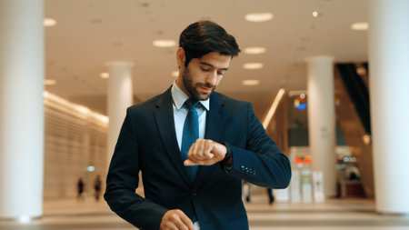 Caucasian smart business man looking at watch while waiting colleague. Executive manager wearing...