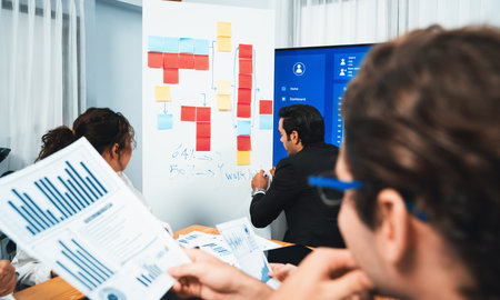 Diverse group of business analyst team analyzing financial data report. Finance data analysis chart and graph dashboard show on TV screen in meeting room for strategic marketing planning. Habilimentの写真素材