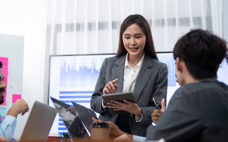 Young asian businesswoman presenting data analysis dashboard on TV screen in modern meeting. Business presentation with group of business people in conference room. Concordの写真素材