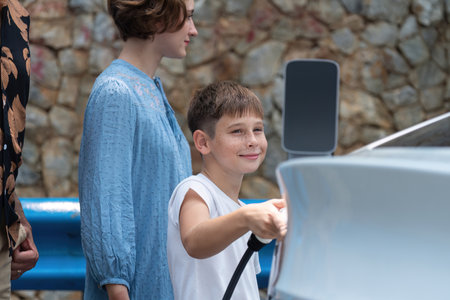 Family road trip vacation with electric vehicle, lovely family recharge EV car with green and clean energy. Stone seawall background and eco friendly car travel for sustainable environment. Perpetualの写真素材