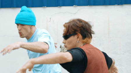 Closeup of hipster group dancing street dance together at wall. Young break dancer team practicing...