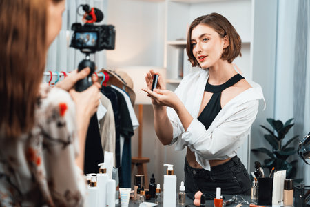 Woman influencer shoot live streaming vlog video review makeup utmost social media or blog. Happy young girl with cosmetics studio lighting for marketing recording session broadcasting online.の写真素材
