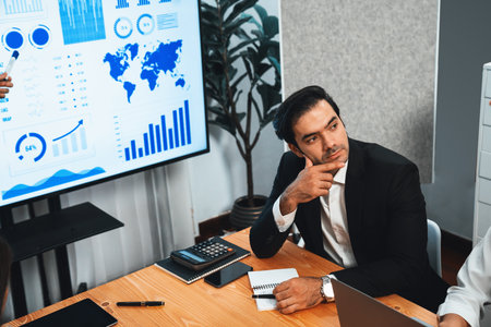 Diverse group of business analyst team analyzing financial data report. Finance data analysis chart and graph dashboard show on TV screen in meeting room for strategic marketing planning. Habilimentの写真素材