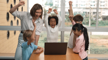 Group of diverse student and teacher celebrate successful project. Happy caucasian instructor looking at engineering code and cheering and encourage learner to improve skill at STEM class. Erudition.の写真素材