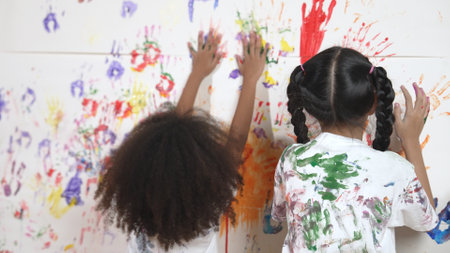 Playful children playing and running with colorful stained hand in front of white background. Funny happy multicultural students enjoy attending in art lesson. Creative activity concept. Erudition.の写真素材