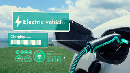 Electric car plug in with charging station, recharge battery by EV charger cable display smart digital battery status hologram with nature background. Futuristic green energy infrastructure.Peruseの写真素材