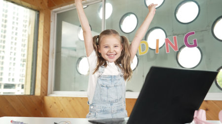 Happy girl looking at camera while raised hands to celebrate success project. Smart cute student...