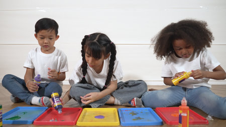 Group of diverse young student mixing color while sitting together. Happy multicultural children prepared mixed to playing and creating new artwork at art lesson. Creative activity concept. Erudition.の写真素材