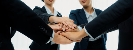 Office worker team stacking hand together symbolize successful group of business partnership and strong collective unity teamwork in community workplace in panoramic banner. Shrewdの写真素材