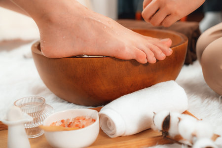 Woman indulges in blissful foot massage at luxurious spa salon while masseur give reflexology therapy in gentle day light ambiance resort or hotel foot spa. Quiescentの写真素材