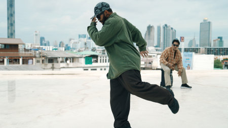 Professional break dance team practice B-boy dance while multicultural friends at rooftop. Young modern dancing group doing hip hop movement. Style,fashion,action. Outdoor sport 2024. Endeavor.の写真素材