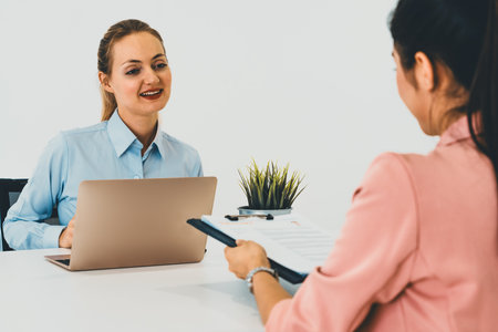 Two young business women in meeting at office table for job application and business agreement....