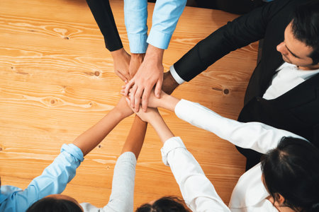 Multiracial business people make synergy hand stack together in meeting room as cooperation or team building for corporate employee in workplace. Habilimentの写真素材