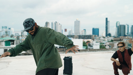 Professional break dance team practice B-boy dance while multicultural friends at rooftop. Young modern dancing group doing hip hop movement. Style,fashion,action. Outdoor sport 2024. Endeavor.の写真素材