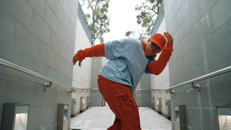 Professional hipster perform footstep while walking at corridor. Skilled street dancer show b-boy dance while perform crazy funny movement to camera. Modern lifestyle. Outdoor sport 2024. Sprightly.の写真素材