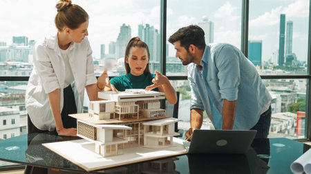 Portrait of skilled architect discussion with engineer team while using laptop. Group of businesspeople brainstorm and analysis building construction. Civil engineering, working together. Traceryの写真素材