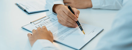 Business executive signing contract agreement document on the bale with the help from company attorney or lawyer service in law firm office. Business investing and finalizing legal processing. Shrewdの写真素材