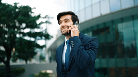 Skilled caucasian project manager calling phone while walking at city with blurred background. Skilled businessman using smart phone talking to project manager with blurred background. Exultant.の写真素材