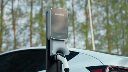 EV electric vehicle recharging battery from EV charging station in national park or outdoor forest...