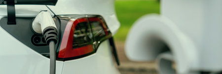 Panorama banner EV electric vehicle recharging battery from EV charging station in national park or outdoor forest scenic. Natural protection with eco friendly EV car travel in the summer woods. Exaltの写真素材