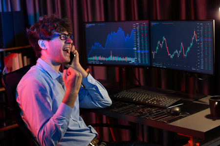 Successful business trader calling on smartphone with raising fist up of highest profit on global...