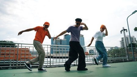 Group of skilled break dancer perform hip hop foot step together at rooftop with city or skyscraper view. Handsome hipster team moving to funky music at public place. Outdoor sport 2024. Sprightly.の写真素材