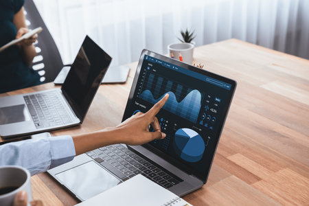 Multiracial analyst team use BI Fintech software to analyze financial data on meeting table. Financial dashboard data display on laptop screen with analyzed chart for marketing indication. Concordの写真素材