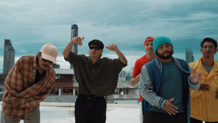 Skilled multicultural street dancing group pose at camera at roof top while moving to the rhyme and music. Young people or teenager moving to funky music, break dance. Outdoor sport 2024. Endeavor.の写真素材