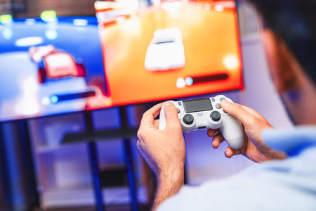 Close up of photo of holding joystick with two hands by gaming streamer playing car racing...