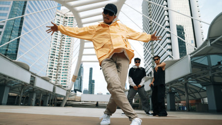 Group of professional street dancer cheer up while asian hipster perform freestyle footstep at city...
