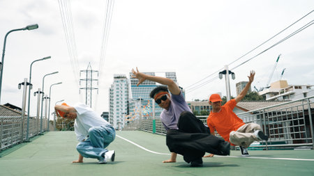 Group of professional break dancer dancing together or moving to hip hop music. Low angle camera of happy hipster team moving footstep and pose at camera. Crossing arm. Outdoor sport 2024. Sprightly.の写真素材
